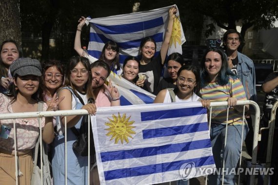 아르헨티나 콜드플레이 공연장 앞에서 기다리는 우루과이 아미들 Uruguayan fans of the South Korean band BTS pose as they queue to access to River Plate's Monumental stadium to attend the fourth of ten concerts of the British rock band Coldplay in Buenos Aires, on October 28, 2022. - South Korean K-Pop boy band BTS member Kim Seo