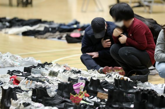 2일 오후 서울 용산구 원효로다목적체육관에 마련된 이태원 압사 참사 유실물 보관소에서 희생자의 유품을 찾은 유가족이 슬픔에 잠겨 있다. 2022.11.2/뉴스1 ⓒ News1 구윤성 기자