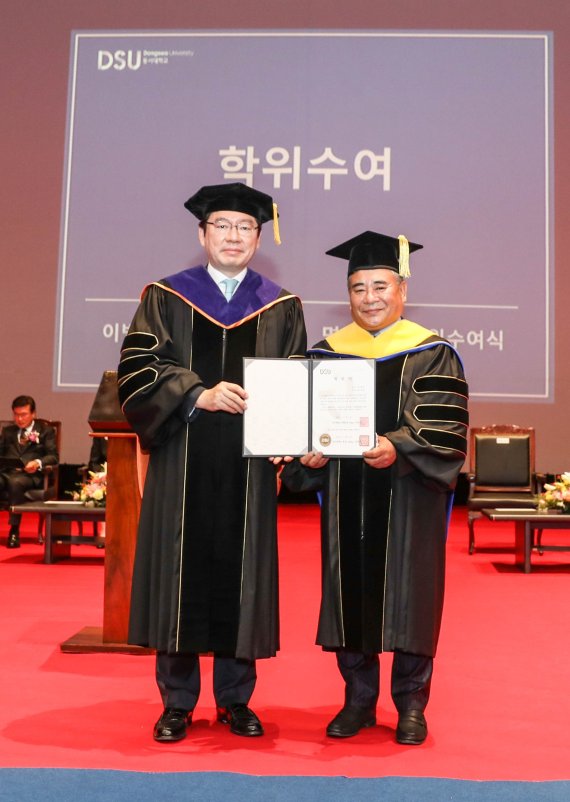 장제국 동서대학교 총장이 이병철 ㈜약손명가 회장(오른쪽)에게 명예이학박사 학위를 수여하면서 기념촬영을 하고 있다. 동서대 제공