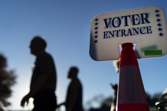 [워릭=AP/뉴시스] 미국 중간선거 사전투표 마지막 날인 7일(현지시간) 미 로드아일랜드주 워릭의 한 투표소에서 투표를 마친 유권자들이 투표소 안내판을 지나고 있다. 2022.11.08. /사진=뉴시스