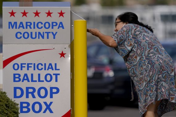 [메사=AP/뉴시스] 미국 중간선거 사전투표 마지막 날인 7일(현지시간) 미 애리조나주 메사에서 한 여성이 투표용지를 선관위 공식 투표함에 넣고 있다. 2022.11.08. /사진=뉴시스