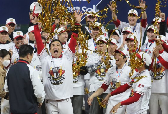 8일 오후 인천시 미추홀구 SSG 랜더스필드에서 열린 프로야구 '2022 신한은행 SOL KBO 포스트시즌' 한국시리즈 6차전 키움 히어로즈와 SSG 랜더스의 경기에서 4대3으로 승리하며 우승을 차지한 SSG 김강민이 한국시리즈 MVP에 선정되자 동료 선수들의 축하를 받고 있다. /뉴스1