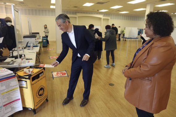 중간선거 불패 신화 속에서 뉴욕증시가 8일(현지시간) 사흘째 상승세를 이어갔다. 미국 캘리포니아주 알라메다에서 캘리포니아주 법무장관인 롭 본타(왼쪽)가 투표용지를 투포함에 넣고 있다. AP뉴시스