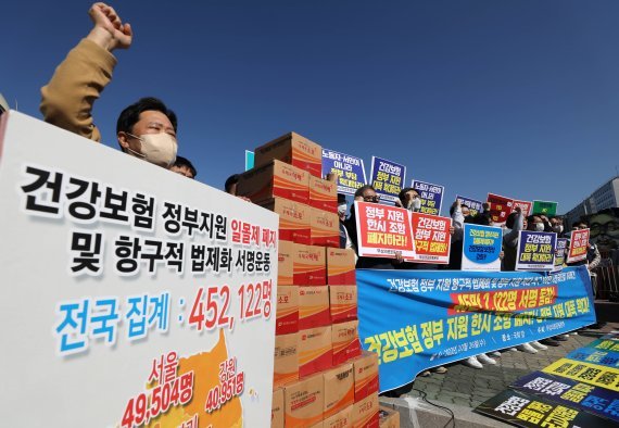 지난달 26일 서울 여의도 국회 앞에서 무상의료운동본부 주최로 열린 ′건강보험 정부 지원 항구적 법제화 기자회견′에서 참석자들이 구호를 외치고 있다./사진=뉴시스화상