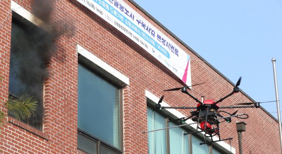 10일 오후 세종시 연기면에서 열린 소방드론 현장 시연회에서 업체 관계자들이 소방드론을 이용해 저층 건물 내 화재발생 초기 화재진압을 위한 시연을 하고 있다. 2022.11.10/뉴스1 ⓒ News1 김기남 기자