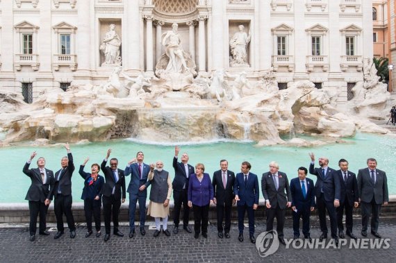 Leaders of the world's twenty leading economies pose for a group photo in front of the Trevi Fountain during the G20 Summit in Rome on October 30, 2021. The summit, taking place over two days in the Italian capital, is the first in-person session of the G20 since the beginning of the COVID-19 pandem