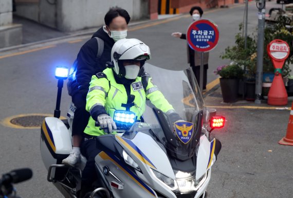 지난해 11월18일 오전 서울 종로구 경복고등학교에 마련된 서울시교육청 제15지구 제1시험장 앞에서 수험생이 경찰 오토바이를 타고 도착하고 있다. 뉴시스 제공