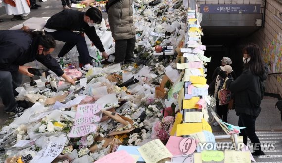 지난 7일 이태원 참사 희생자 추모공간인 이태원역 1번 출구에서 자원봉사자들이 꽃을 정리하고 있다. 국가애도기간은 지난 5일 종료됐지만 추모 발길은 이어지고 있다. 연합뉴스