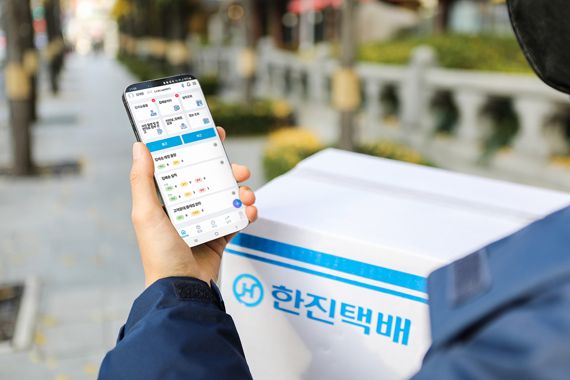 한진택배기사가 신규 전용 앱을 보고 배송을 하고 있는 모습. 한진 제공