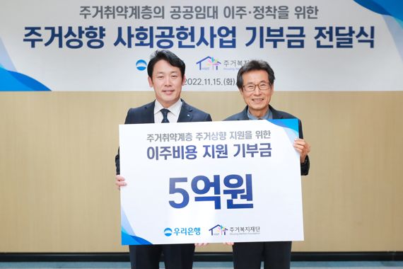 우리은행 심기우 부동산금융그룹장(왼쪽)과 주거복지재단 장경수 대표이사가 지난 15일 주거복지재단에서 주거상향 사회공헌사업 기부금 전달식을 가지고 기념촬영을 하고 있다. 우리은행 제공