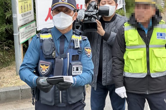 [제주=뉴시스] 이정민 기자 = 2023학년도 대학수학능력시험일인 17일 오전 제주도교육청 95지구 제1시험장인 남녕고등학교 입구에서 경찰이 학부모로부터 전달받은 수험생 수험표를 가지고 수험장을 향하고 있다. 2022.11.17. 73jmlee@newsis.com