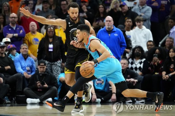 커리 상대로 공격하는 부커 Phoenix Suns guard Devin Booker drives as Golden State Warriors guard Stephen Curry, left, defends during the first half of an NBA basketball game, Wednesday, Nov. 16, 2022, in Phoenix. (AP Photo/Matt York)