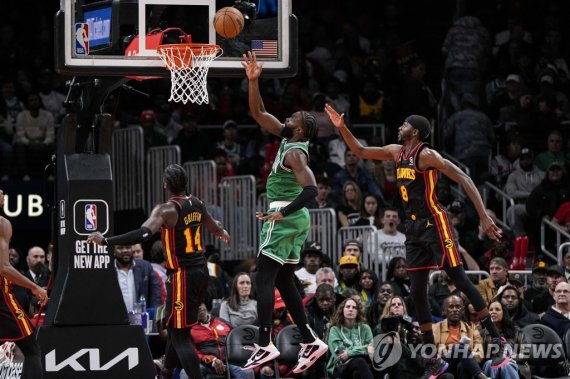 레이업하는 제일런 브라운 Nov 16, 2022; Atlanta, Georgia, USA; Boston Celtics guard Jaylen Brown (7) scores basket between Atlanta Hawks forwards AJ Griffin (14) and Justin Holiday (8) during the second half at State Farm Arena. Mandatory Credit: Dale Zanine-USA TODAY Sports