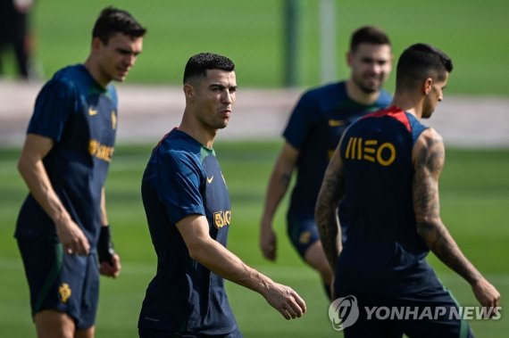 호날두와 포르투갈 선수들 Portugal's forward Cristiano Ronaldo (C) arrives for a training session at Shahaniya Sports Club in Al Samriya, northwest of Doha on November 20, 2022 during the Qatar 2022 World Cup football tournament. (Photo by Patricia De Melo MOREIRA / AFP)