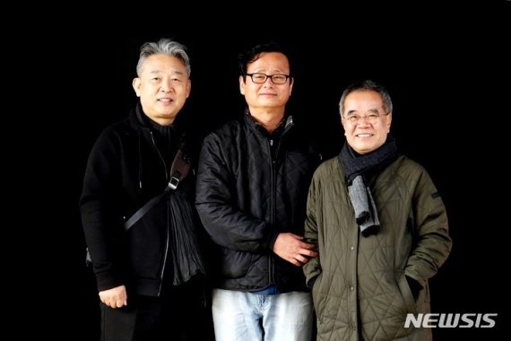 [익산=뉴시스]박진희 기자=춘포도정공장을 예술로 만든 3인방. 왼쪽부터 조덕현 작가, 춘포도공정공장은 전시장으로 만든 서문근 대표, 김용택 섬진강 시인이 어둠을 삼킨 건물을 배경으로 사진을 찍고 있다.