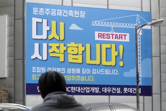 16일 서울 강동구 둔촌주공 재건축 현장에 공사 재개를 알리는 현수막이 붙어 있다.