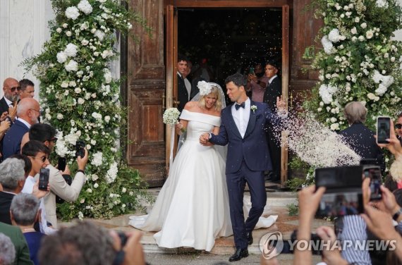 epa10142092 Retired Italian swimmer Federica Pellegrini (L) is accompanied by her husband Matteo Giunta (R) as they leave the church of San Zaccaria, where she married her coach, in Venice, Italy, 27 August 2022. Federica Pellegrini won a gold medal at the 2008 Beijing Olympics and hold various Worl
