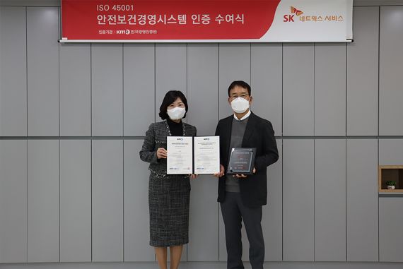 이정재 SK네트웍스서비스 경영지원실장(오른쪽)과 황은주 한국경영인증원 대표이사가 안전보건경영시스템 인증 수여식에서 기념촬영을 하고 있다. SK네트웍스 제공