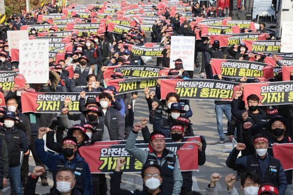 24일 오전 경기도 의왕시 내륙컨테이너기지(ICD) 앞에서 열린 화물연대 서울경기지부 총파업 출정식에서 노조원들이 구호를 외치고 있다. 민주노총 공공운수노조 화물연대본부는 안전운임제 일몰제 폐지와 적용 차종·품목 확대 등을 요구하며 이날 0시부터 총파업에 돌입했다.