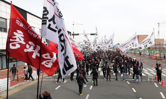 민주노총 전국공공운수노동조합 화물연대 총파업과 관련해 울산본부 조합원들이 24일 오전 울산 남구 울산신항 앞에서 열린 총파업 출정식에서 깃발을 앞세워 입장하고 있다. 화물연대는 안전운임 일몰제 폐지, 안전운임제 전차종, 전품목으로 확대, 노동기본권 확대·화물노동자 권리보장 등을 요구하고 있다. /사진=뉴스1