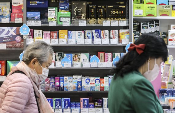 서울 시내 한 약국에서 시민들이 약을 구매하고 있다. 코로나19 재확산과 계절 독감 유행 등에 따른 감기약 부족 사태가 우려되는 가운데 정부는 제약업계의 요구를 받아들여 약가 인상을 추진한다고 밝혔다. 뉴시스 제공.