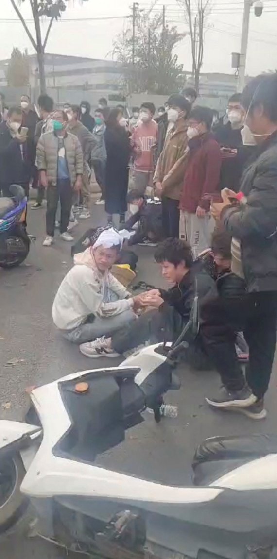 23일(현지시간) 세계 최대 규모 아이폰 생산지인 중국 정저우의 폭스콘 공장에서 임금 체불과 코로나19 방역에 항의하는 시위 중 부상을 입은 근로자가 치료를 받고 있다. ⓒ 로이터=뉴스1 ⓒ News1 우동명 기자