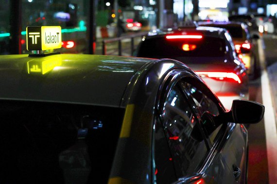늦은 밤 서울역 택시 승강장에서 한 시민이 카카오T 택시를 이용하고 있다. 뉴시스