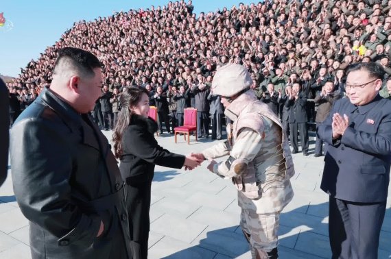 김정은 북한 국무위원장의 둘째 딸이 대륙간탄도미사일(ICBM) '화성-17형' 개발 공로자로 보이는 한 군인과 악수하고 있다. [조선중앙TV 화면]