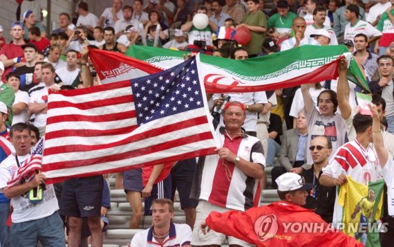 1998년 프랑스 월드컵에서 이란과 미국 축구팬들 (FILES) In this file photo taken on June 21, 1998, Iranian and American supporters wave their national flags as they cheer for their teams during the France 1998 World Cup football match between Iran and USA at the Gerland stadium in Lyon on June 21, 1998. - Iran and the 