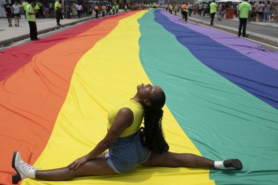 [리우데자네이루=AP/뉴시스] 27일(현지시간) 브라질 리우데자네이루 코파카바나 해변에서 제27회 게이 프라이드 퍼레이드(Gay Pride Parade)가 열려 한 여성이 대형 무지개 깃발 위에 앉아 사진 포즈를 취하고 있다. 2022.11.28.