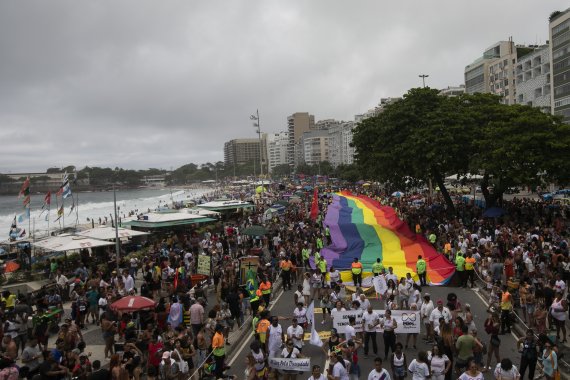 [리우데자네이루=AP/뉴시스] 27일(현지시간) 브라질 리우데자네이루 코파카바나 해변에서 제27회 게이 프라이드 퍼레이드(Gay Pride Parade)가 열려 참가자들이 대형 무지개 깃발을 들고 행진하고 있다. 2022.11.28.