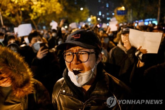 28일(현지시간) 중국 베이징에서 고강도 코로나19 정책에 반대하는 시위와 우루무치시 화재 사건 희생자들을 위한 집회가 함께 진행되면서 시위자들이 거리를 따라 행진하고 있다. 지난 24일 신장웨이우얼자치구 우루무치시 고층 아파트에 발생한 화재 사건으로 촉발된 '제로 코로나' 정책에 대한 시민들의 반대시위가 점차 확대되는 양상을 보이고 있다. 사진=AFP연합뉴스