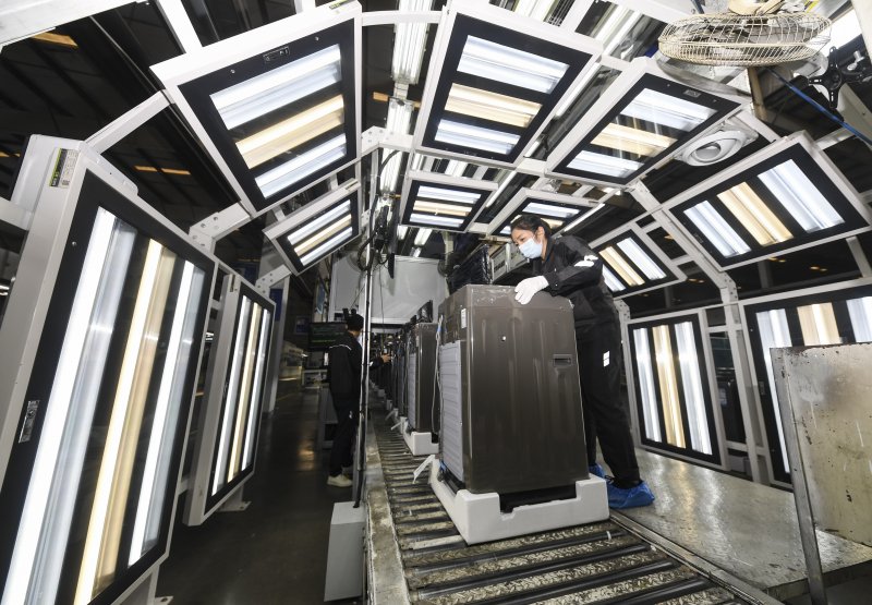 충칭시에 위치한 하이얼 공장에서 직원이 세탁기를 확인하고 있다/신화통신