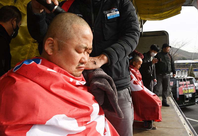 정부가 민주노총 공공운수노조 화물연대본부 총파업에 대해 업무개시명령을 발동한 경기 의왕시 내륙컨테이너기지(ICD)에서 열린 결의대회에서 이광재(왼쪽) 화물연대본부 서울경기지역본부장과 이봉주 화물연대본부 위원장이 명령 발동에 반발하며 삭발하고 있다. 사진=박범준 기자