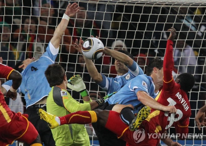 2010년 남아공 월드컵 가나와 8강전에서 손으로 슈팅 막는 수아레스 (FILES) In this file photo taken on July 2, 2010 Uruguay's goalkeeper Fernando Muslera (C) eyes Uruguay's striker Luis Suarez (3rdR) touching the ball during the 2010 World Cup quarter final Uruguay vs Ghana on July 2, 2010 at Soccer City stadium in Soweto, sub