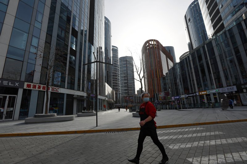중국 수도 베이징에서 4000명에 육박하는 코로니19 신규 확진자가 나온 28일 한 식당 종업원이 빌딩 사이를 지나가고 있다. ⓒ 로이터=뉴스1 ⓒ News1 최종일 기자
