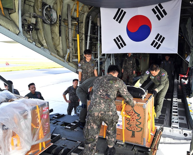 미국 괌 앤더슨 공군기지에서 4일(현지시간) 크리스마스 공수작전에 참가한 공군 제15특수임무비행단 소속 작전요원들이 마이크로네시아(Micronesia) 지역 주민들에게 공수할 생필품이 담긴 화물을 C-130 수송기에 적재하고 있다. 사진=공군 제공