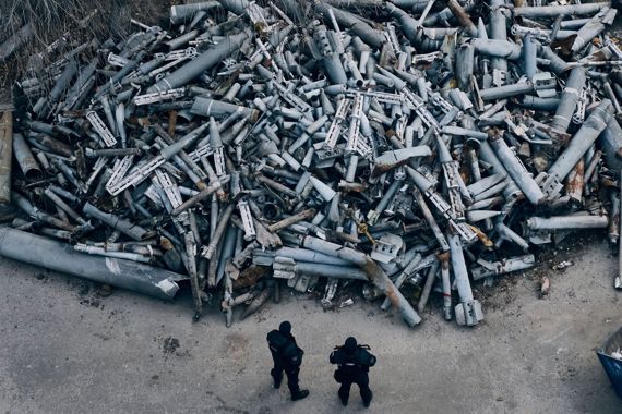 공터에 산처럼 쌓인 러시아 미사일 잔해를 바라보는 우크라이나 현지 경찰. /사진=존 스펜서 트위터 (@SpencerGuard)
