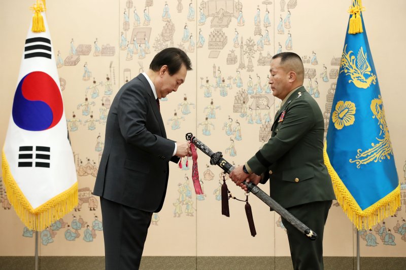 김계환 해병대사령관 삼정검에 수치 달아주는 윤석열 대통령 (서울=연합뉴스) 서명곤 기자 = 윤석열 대통령이 7일 오전 서울 용산 대통령실 청사에서 열린 장성 보직 신고 및 삼정검 수치 수여식에서 김계환 해병대 사령관의 삼정검에 수치를 달아주고 있다. 삼정검은 준장 진급자에게 수여되는 검으로 호국·통일·번영의 의미를 담고 있으며, 이후 중장 이상 진급자에게는 삼정검을 부여받은 이의 보직과 계급, 이름 그리고 수여 당시 대통령 이름이 새겨진 수치(끈으로 된 깃발)를 수여하고 있다. 2022.12.7 [대통령실통신사진기자단] seepho