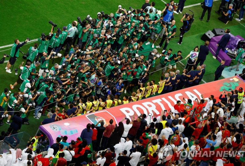 포르투갈 벤치 앞에 몰린 사진 기자들의 모습. Soccer Football - FIFA World Cup Qatar 2022 - Round of 16 - Portugal v Switzerland - Lusail Stadium, Lusail, Qatar - December 6, 2022 Photographers take pictures of Portugal's Cristiano Ronaldo and teammates on the substitutes bench before the match REUTERS/Peter Cziborra T