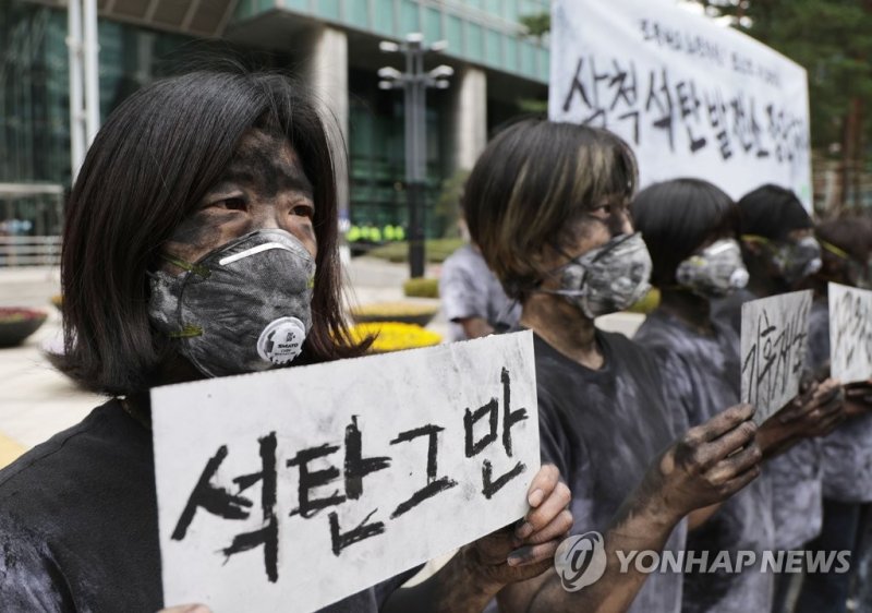석탄 화력발전소를 반대하는 환경단체의 퍼포먼스 '석탄그만' (서울=연합뉴스) 한종찬 기자 = 18일 오전 서울 강남구 포스코센터 앞에서 녹색연합 관계자가 삼척블루파워석탄발전소 건설 중단을 촉구하며 퍼포먼스를 하고 있다. 2022.3.18 saba@yna.co.kr (끝)