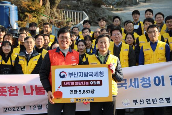 부산지방국세청이 7일 추운 겨울 날씨 속에 '사랑의 연탄'을 기탁하고 직접 배달까지 해 훈훈함을 전했다. 노정석 청장(앞줄 오른쪽)과 강정칠 부산연탄은행 대표(앞줄 왼쪽)가 참여한 국세청 직원들과 포즈를 취하고 있다. 사진=부산지방국세청 제공