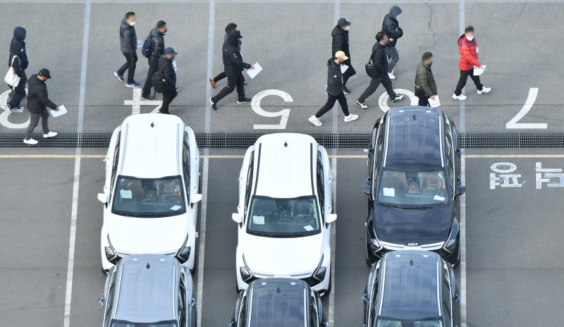 [광주=뉴시스] 김혜인 기자 = 화물연대 총파업 일주일째인 30일 오전 광주 서구 기아 오토랜드 광주2공장에서 기아측이 고용한 완성차 운송 대체 인력이 차량을 옮기기 위해 들어서고 있다. 2022.11.30.hyein0342@newsis.com