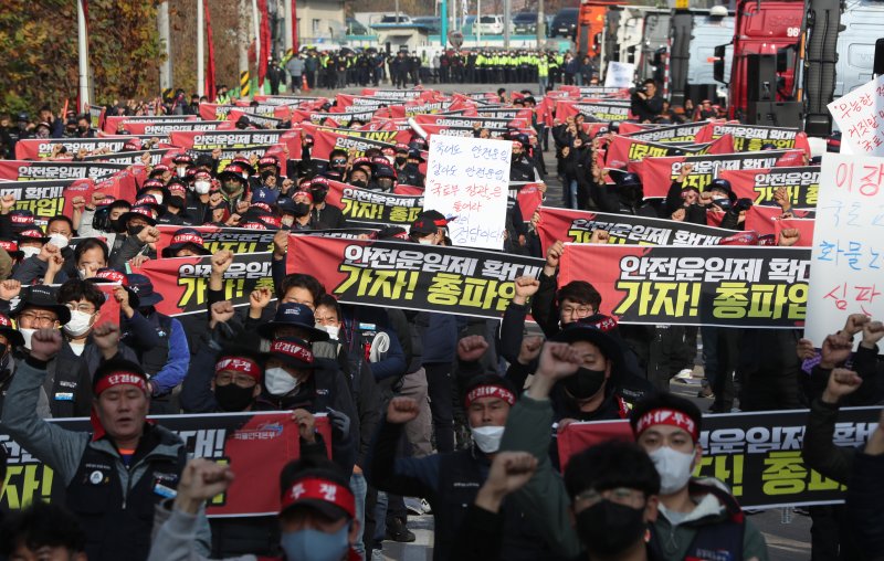 민주노총 공공운수노조 화물연대본부가 무기한 총파업에 돌입한 24일 오전 경기 의왕시 의왕ICD 오거리에서 열린 화물연대 총파업 출정식에서 민주노총 화물연대 소속 노조원들이 안전운임제 확대를 요구하며 구호를 외치고 있다. 2022.11.24/뉴스1 ⓒ News1 김영운 기자