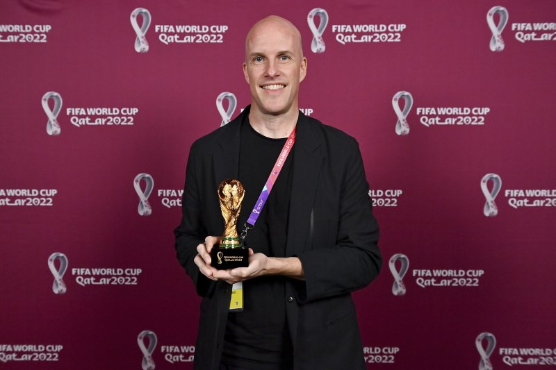Grant Wahl smiles as he holds a World Cup replica trophy during an award ceremony in Doha, Qatar on Nov. 29, 2022. Wahl, one of the most well-known soccer writers in the United States, died early Saturday Dec. 10, 2022 while covering the World Cup match between Argentina and the Netherlands. (Brenda