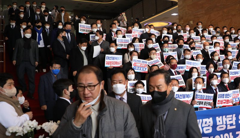 국민의힘 의원들이 11일 국회 로텐더홀 계단에서 이상민 행정안전부 장관 해임 건의안 강행 처리를 규탄하는 피켓을 들고 있는 가운데 본회의 표결을 마친 더불어민주당 의원들이 계단을 내려오고 있다. 연합뉴스