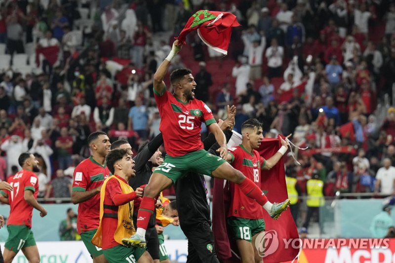 CORRECTS TEAM AND NAME TO MOROCCO'S YAHIA ATTIYAT ALLAH INSTEAD OF PORTUGAL'S OTAVIO - Morocco's Yahia Attiyat Allah (25) celebrates with teammates after the World Cup quarterfinal soccer match against Portugal at Al Thumama Stadium in Doha, Qatar, Saturday, Dec. 10, 2022. (AP Photo/Martin Meissner)