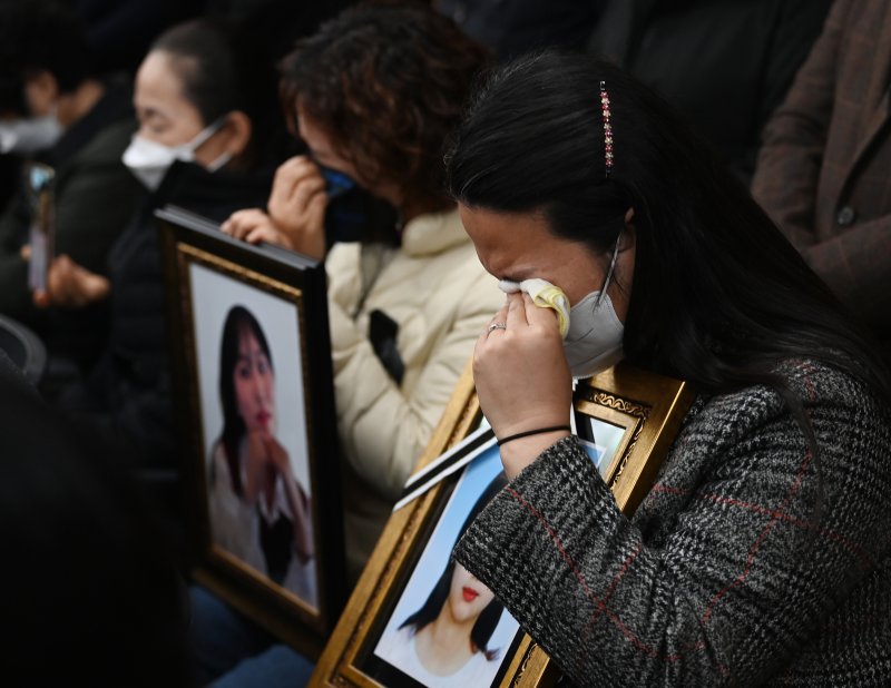 이태원 참사 유가족들이 22일 오전 서울 서초구 민주사회를 위한 변호사모임(민변) 대회의실에서 열린 입장발표 기자회견에서 자식의 영정사진을 품에 안고 눈물을 흘리고 있다. (공동취재) 2022.11.22/뉴스1 ⓒ News1 민경석 기자