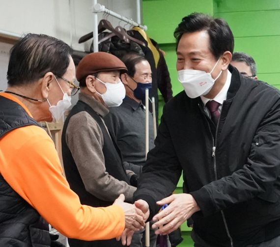 오세훈 서울시장(오른쪽)이 13일 서울 송파구 송파노인종합복지관에서 열린 '100세 마당' 개방식에 참석해 어르신과 인사하고 있다. 오시장의 마스크에 써있는 '약자와의 동행'은 오시장이 추구하는 핵심가치이자 시정철학이다./ 제공 서울시