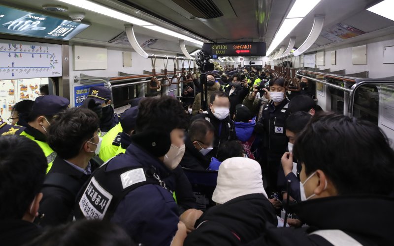 전국장애인차별철폐연대(전장연) 회원들이 14일 오전 서울 용산구 삼각지역에서 지하철 탑승 시위 도중 경찰과 갈등을 빚고 있다. 이날 전장연 회원들의 지하철 내 사다리 반입 시도로 당고개 방면 열차 1대가 무정차 통과했다. 뉴스1